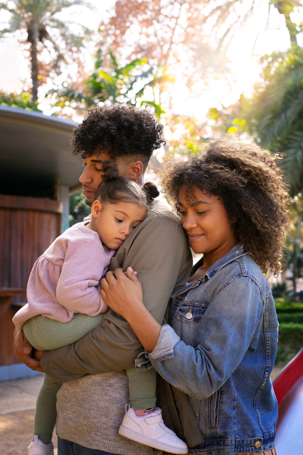 A smiling family of three poses together, reflecting the positive impact of teen and family therapy at Advanced Client Care
